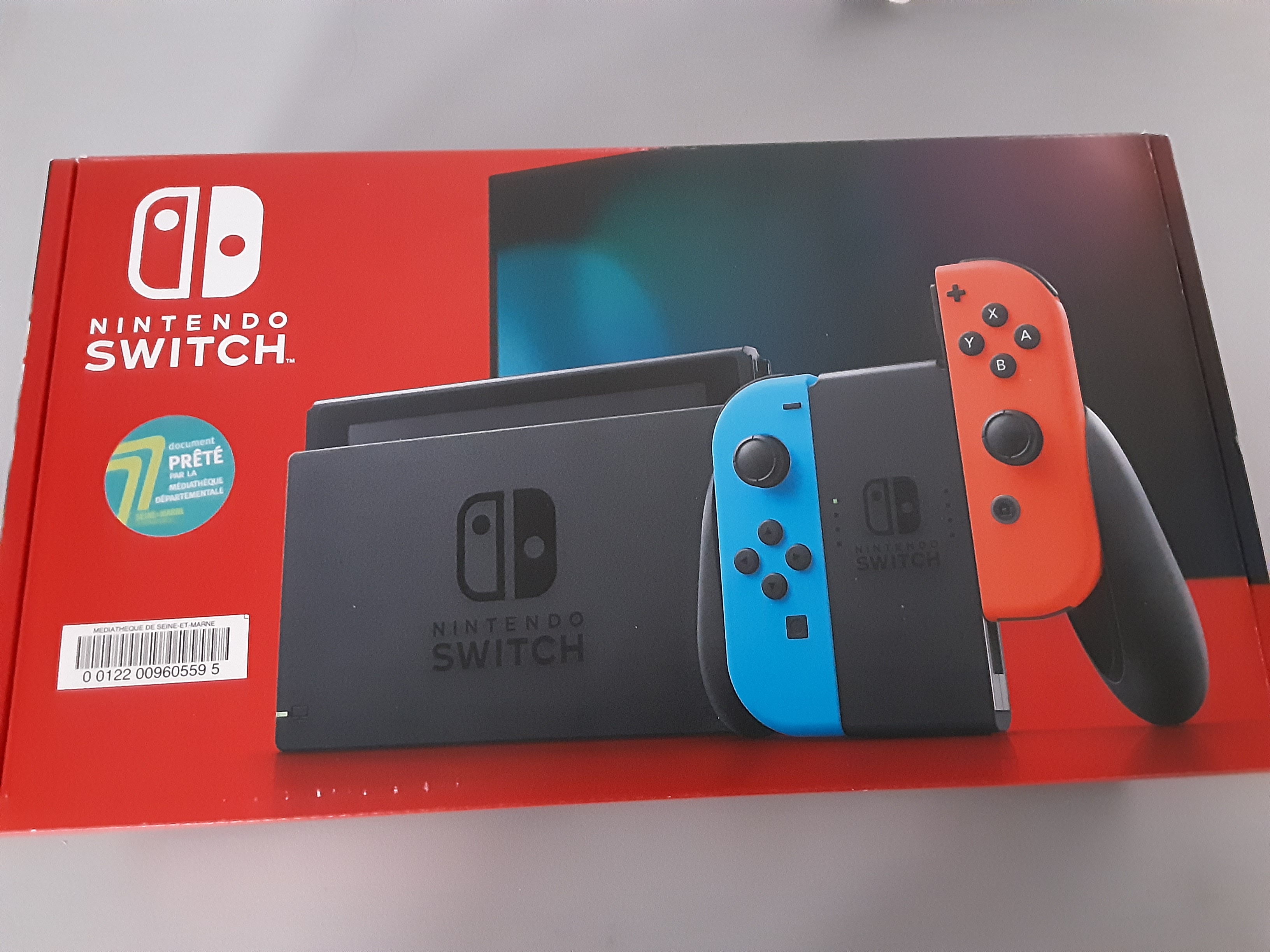 boite de la console nintendo switch avec le code-barres et la pastille 77 de la médiathèque départementale